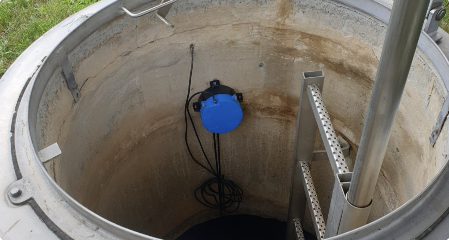 AQ IoT data logger installed inside a street manhole with green LED indicator